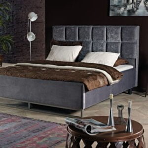 Gestoffeerd bed Dubai met grijze bekleding, metalen poten, bruin dekbed en witte kussens