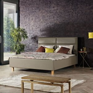 gestoffeerd bed Kopenhagen opgemaakt in de kamer met een grijs bruine kleur