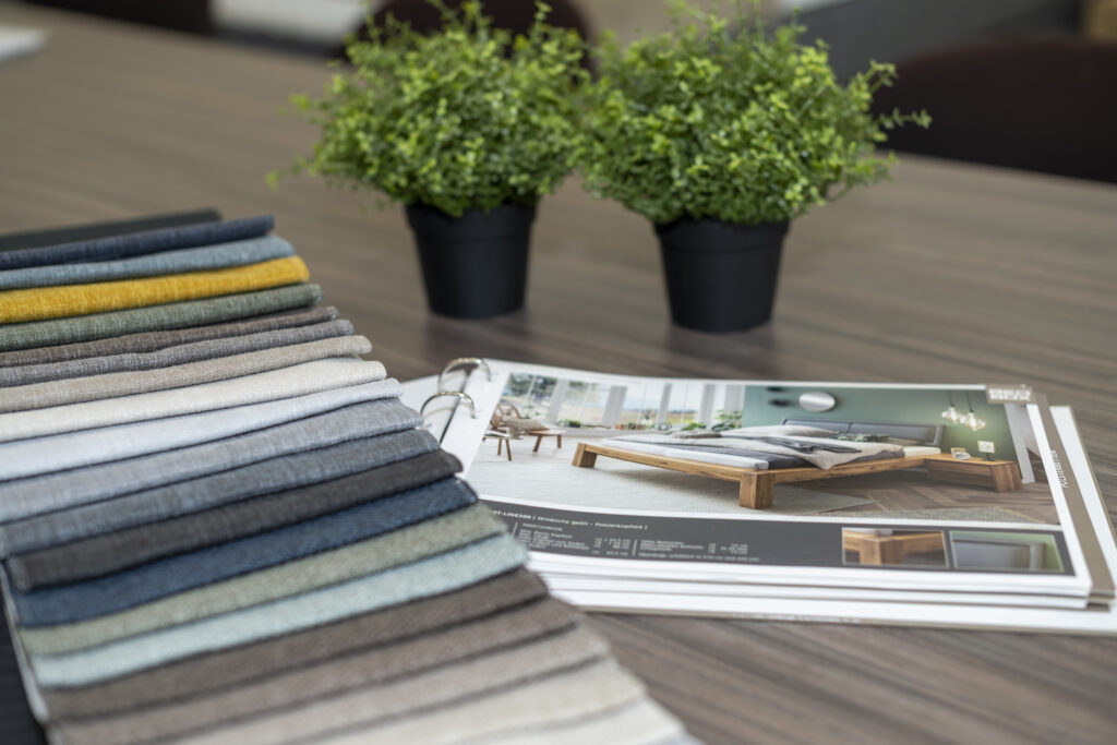 kleurenpallet in de showroom met daarbij een catalogus van het assortiment bedden.